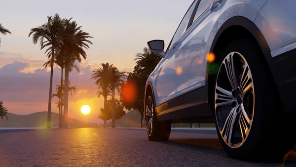 Placeholder text of image details: A safe, modern car driving on a coastal road at sunset, symbolizing security and good value insurance.